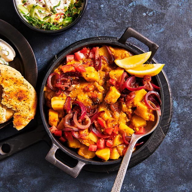 Dal tarka met trostomaten, aardappel en gekarameliseerde uitjes