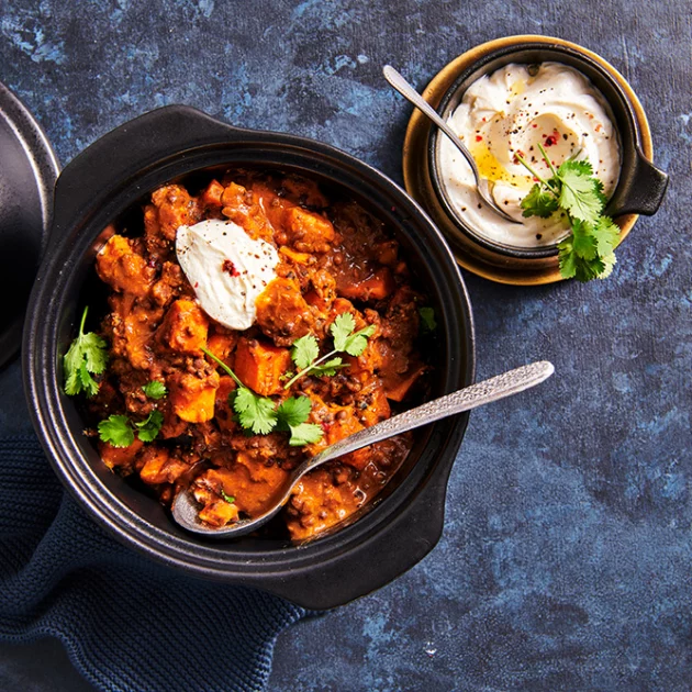 Dal makhani met zoete aardappelblokjes, koriander en crème fraiche 